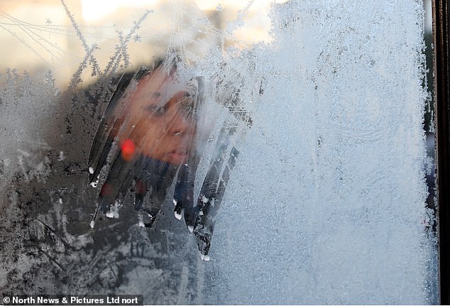 A commuter waits in a frozen over bus stop in Low Fell, Gateshead ths morning