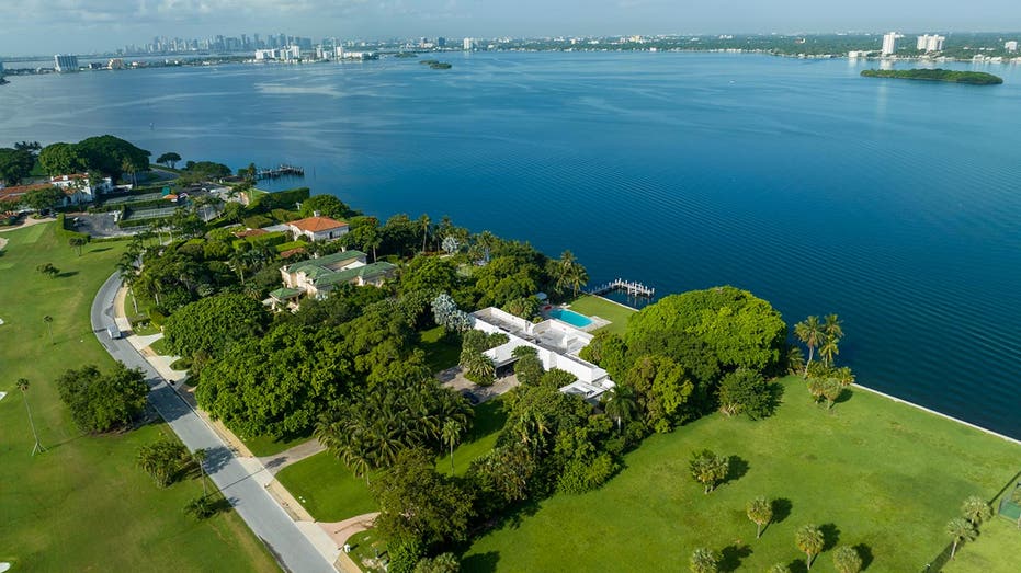 An overheard view of the home with water in the background and Miami's skyline in the far distance.