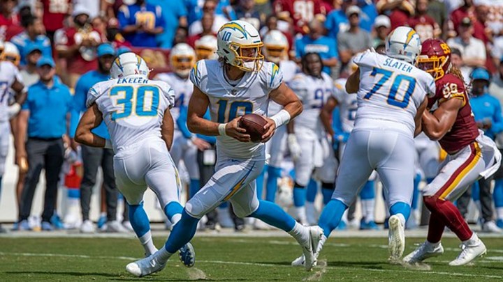 A quarterback drops back with the ball.