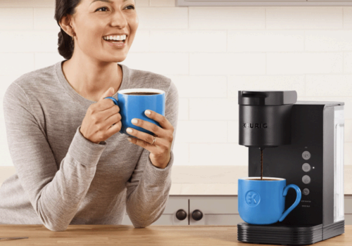 A woman sitting next to a Keurig K-Express coffee maker.