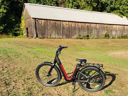 NIU BQi-C3 Pro left side with a Connecticut Tobacco Valley shed tobacco barn in the background.