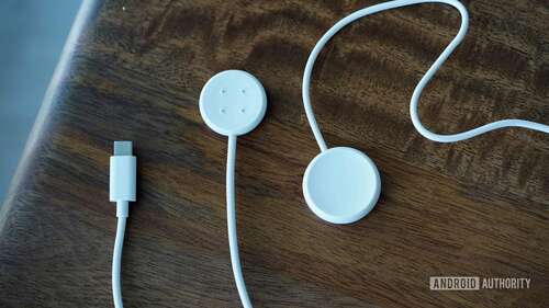 A Pixel Watch 2 charger rests alongside an original Pixel Watch charger.