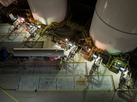 An aerial view above an industrial gas facility with a tanker is being filled.