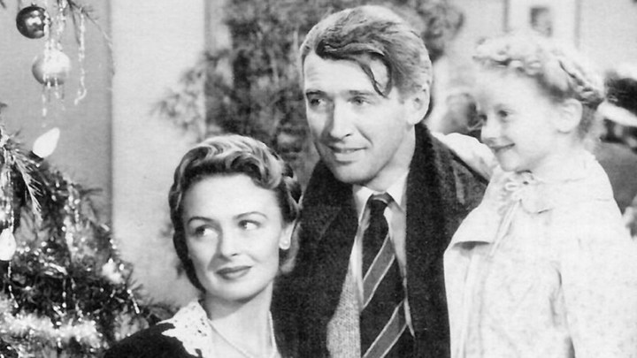 Jimmy Stewart as George Bailey holding his wife in one arm and his daughter in another in "It's A Wonderful Life."