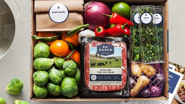 box of food items from blue apron, including meat, veggies, potatoes and herbs