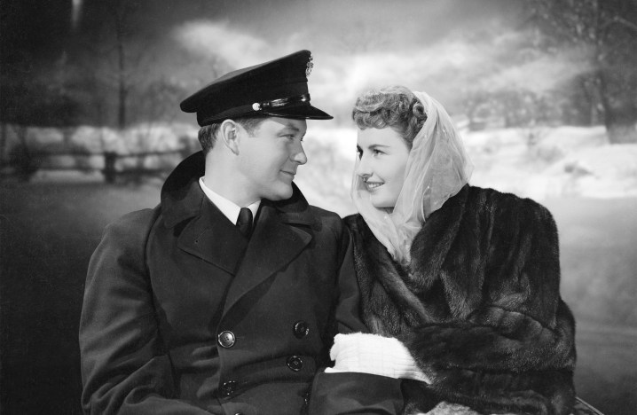 A man and a woman ride a sleigh in Christmas in Connecticut.