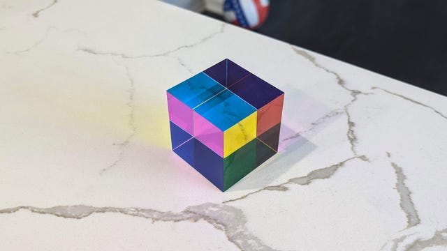 A glass cube that reflects colors in a rainbow pattern