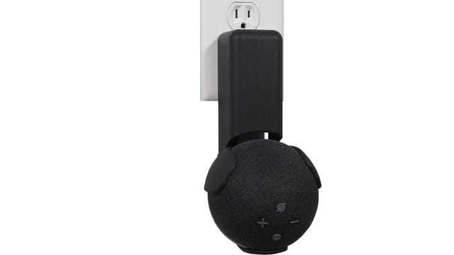 A black Amazon Echo Dot hanging from a grip in an outlet