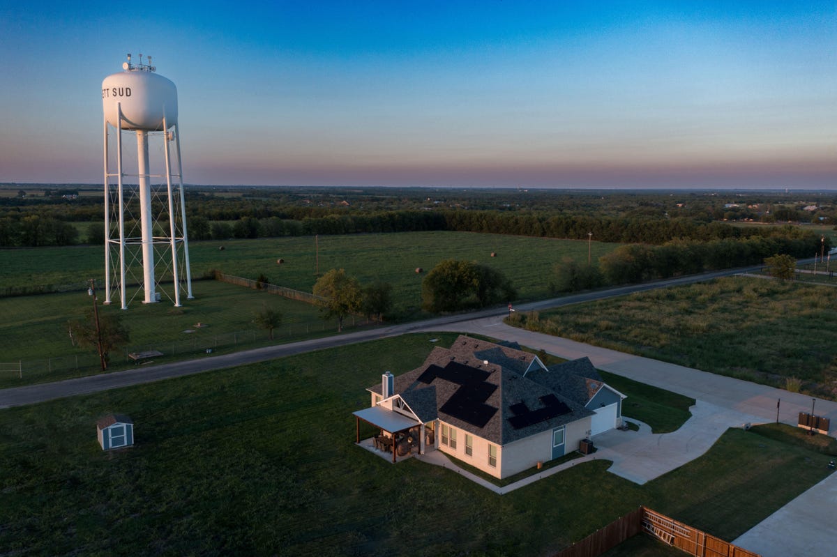 A rooftop solar installation next to a white water tower.