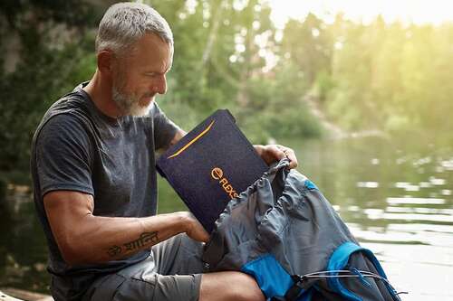 FlexSolar 40W Solar Charger being put in a backpack