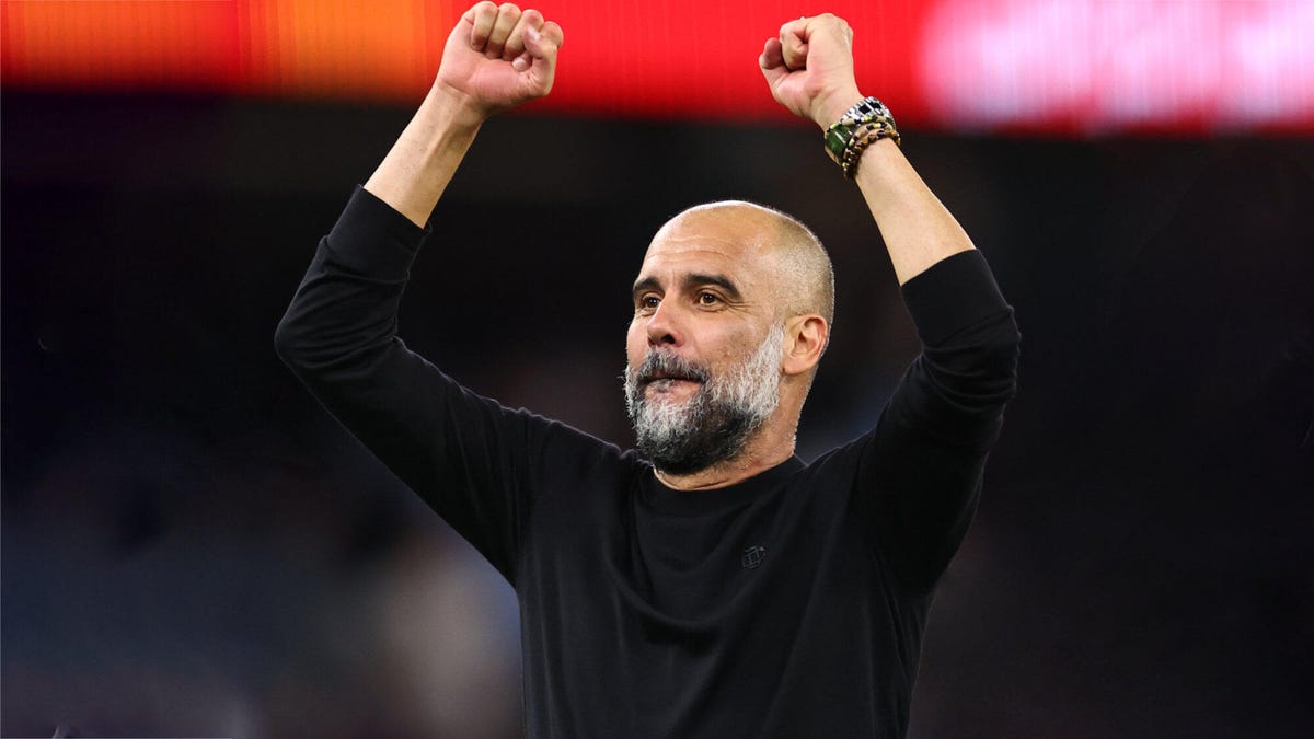 Pep Guardiola raises his fists in triumph