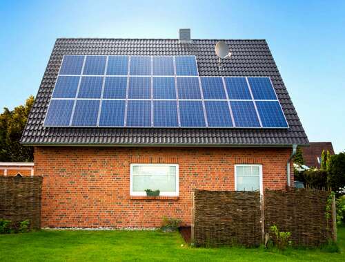 Solar panels on the roof of a brick house.