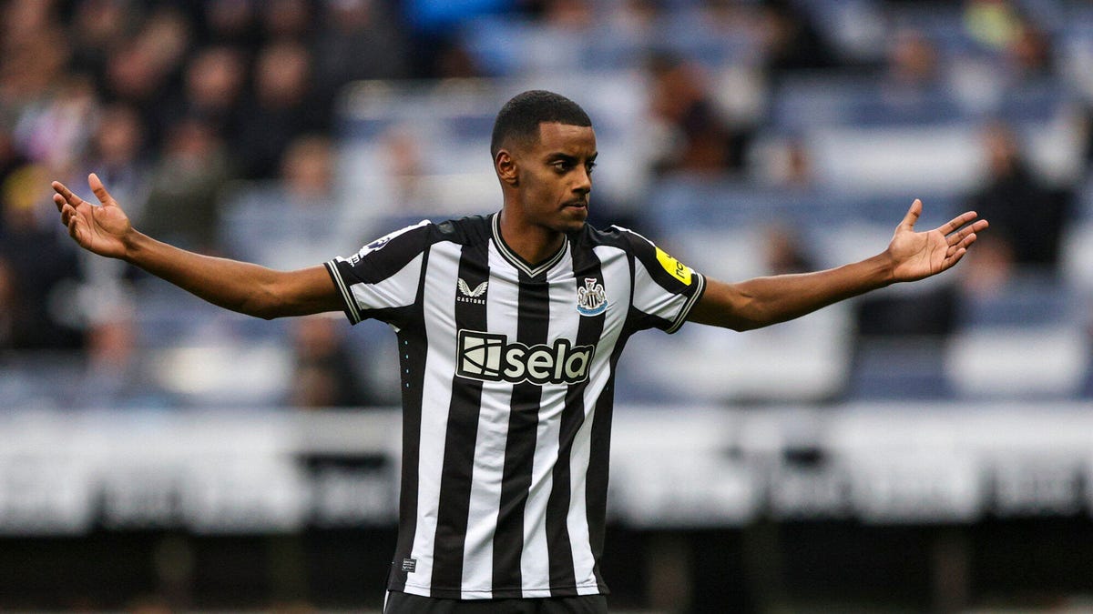 Newcastle United forward Alexander Isak standing with both arms outstretched.