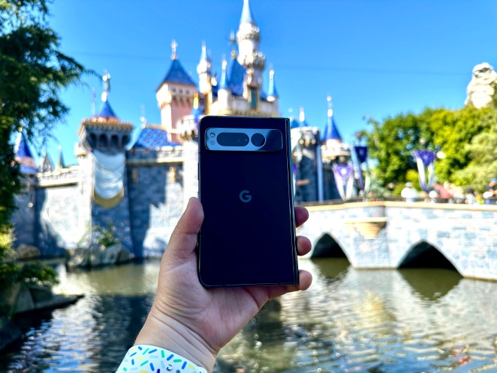 Google Pixel Fold in Obsidian in hand at Disneyland castle.