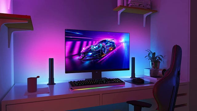 A monitor backlit by purple and blue lights