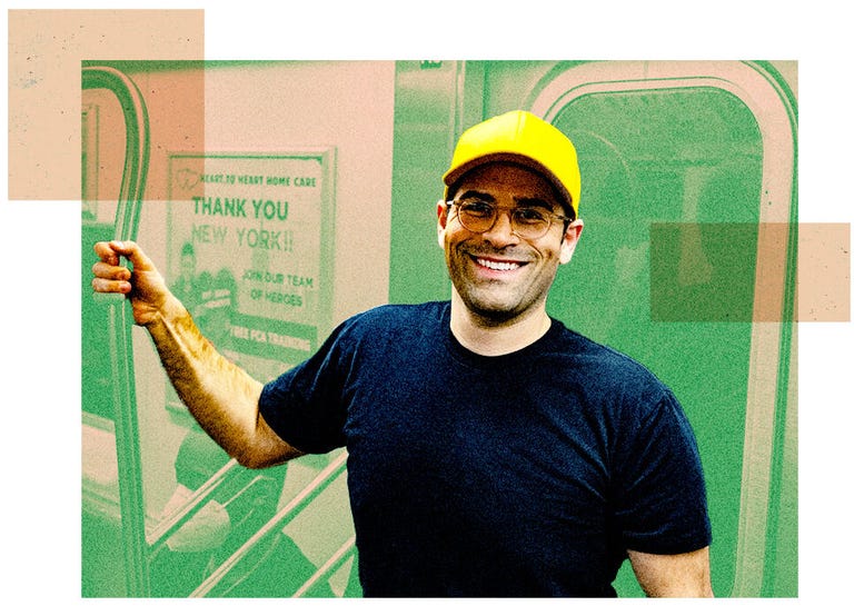 A man wearing a dark blue T-shirt and a bright yellow baseball cap.