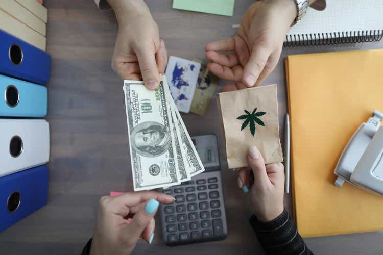 Closeup of burning packet of marijuana for cash dollars