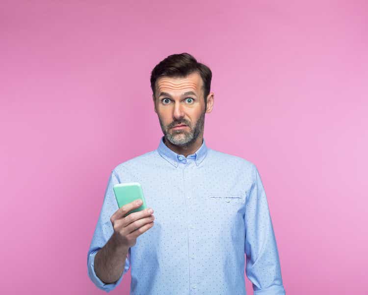 Shocked man holding mobile phone