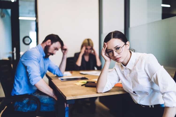 Fatigued colleagues working hard at desk at office