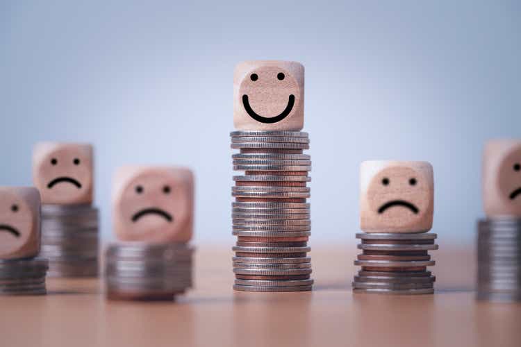 Coin stacking on smiley face and sad face for good financial planing can make happiness in life, Money saving and investment concept.