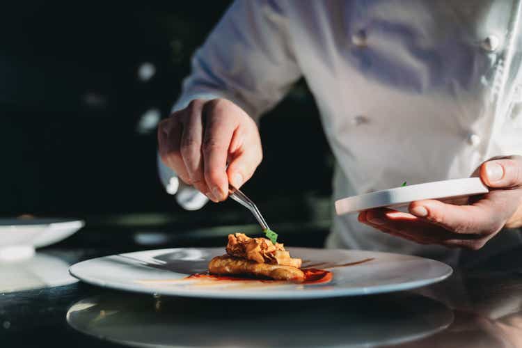 A chef is finishing the preparation of the plate