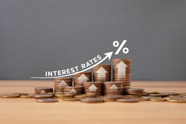 Stacked of Coins on table with percentage icon and Gray Background With Illustration Shows Increasing of Interest Rates / Financial Concept.