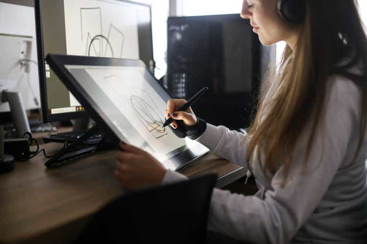 Young woman drawing using a pen tablet