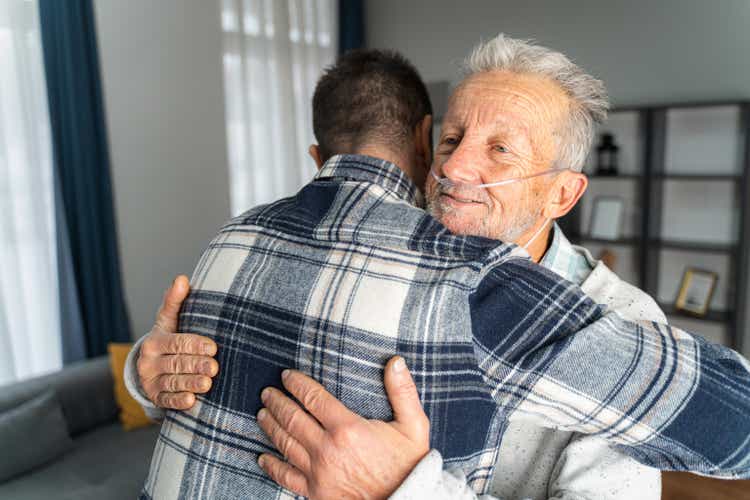 man and his senior father embracing