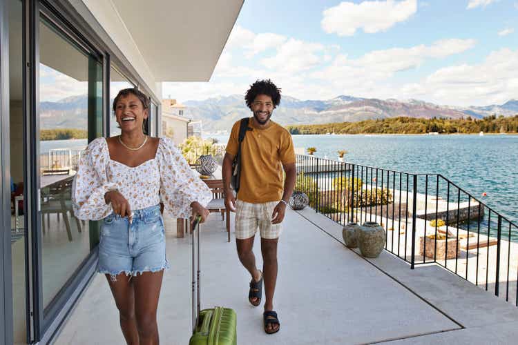 Young couple walking on deck by sea in summer