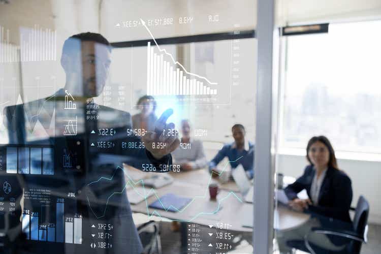 Man in a business meeting using an interactive screen while giving a presentation