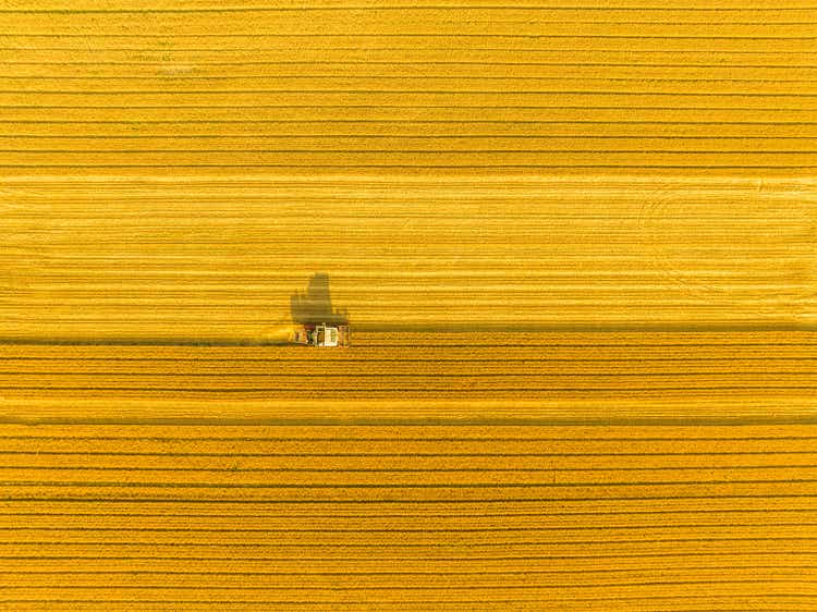 Combine harvester harvesting wheat in agricultural field