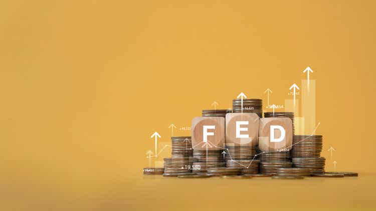 Stack of coins and wooden blocks with FED and graph up. Stack of coins with graph chart growth up, Business marketing. Idea of raising interest rates by the Fed to reduce inflation. economy and business