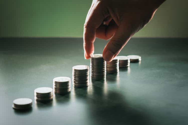 Hand holding coins stacked together. Concepts: finance, economy, investment, interest, tax and banking, etc.