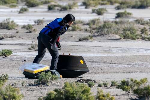 Engineer inspecting the landed asteroid sample capsule