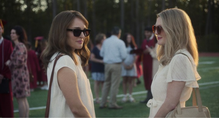 Two women talk in a field in May December.