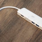 Monoprice's white six-in-one USB-C travel dock sitting on a wood table.