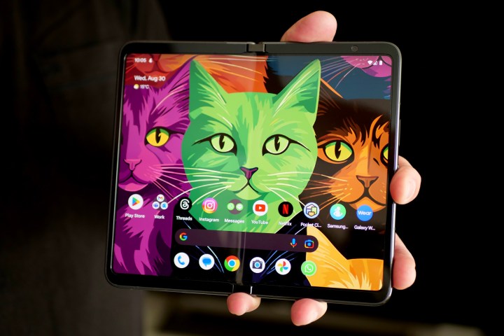 A person holding the Google Pixel Fold with the screen open.