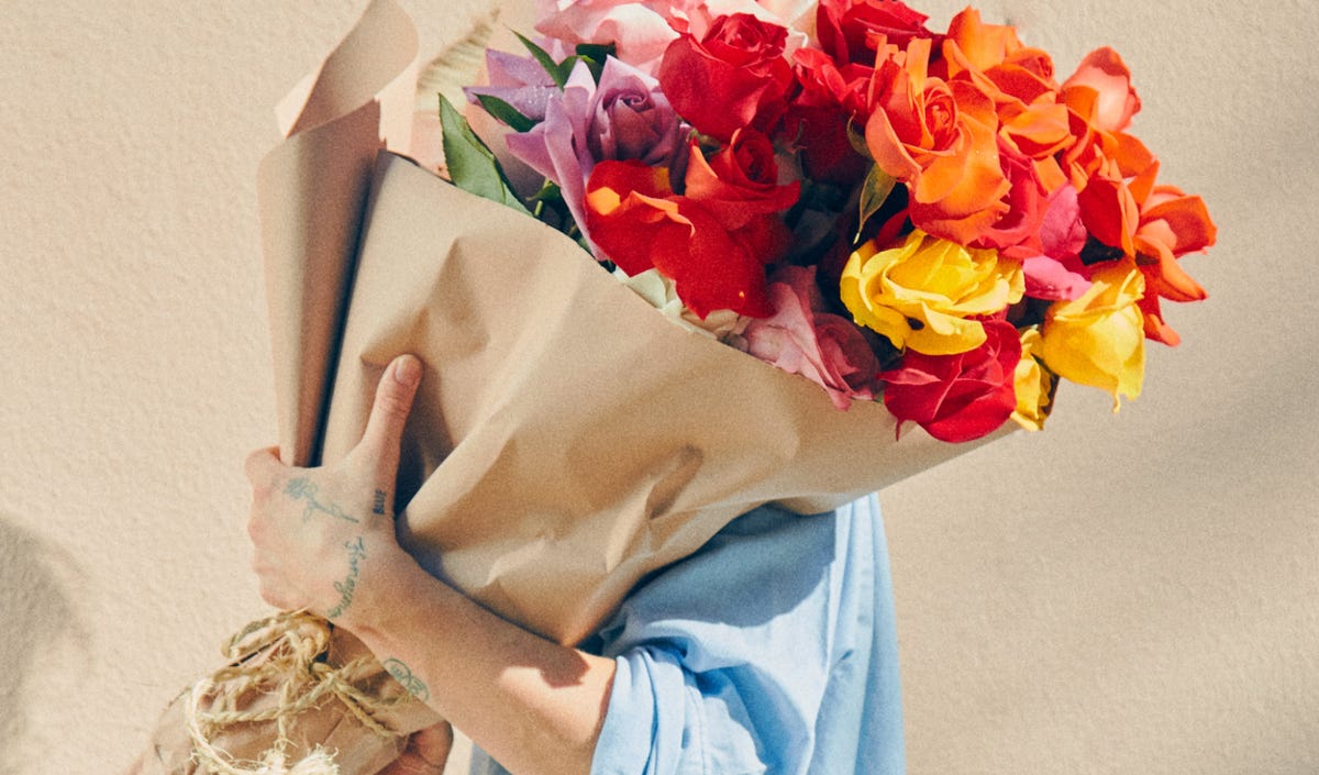 A bouquet of assorted roses in classic brown wrapping paper.