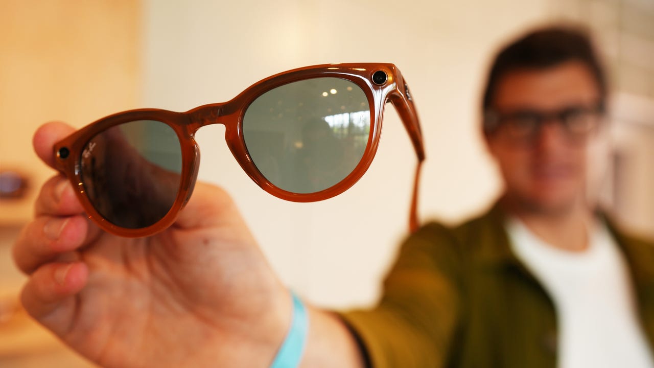 A person holding up the Meta Ray Ban smart glasses