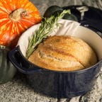 navy dutch oven with sourdough bread on table