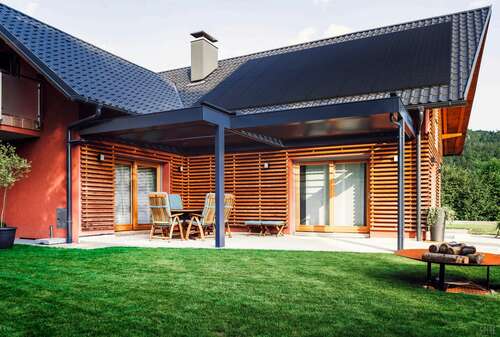 Solar panels on a roof top over a patio.