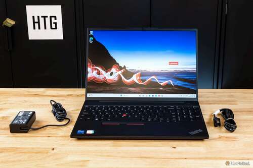 Lenovo ThinkPad E16 Gen 1 open on a desk with its AC adapter