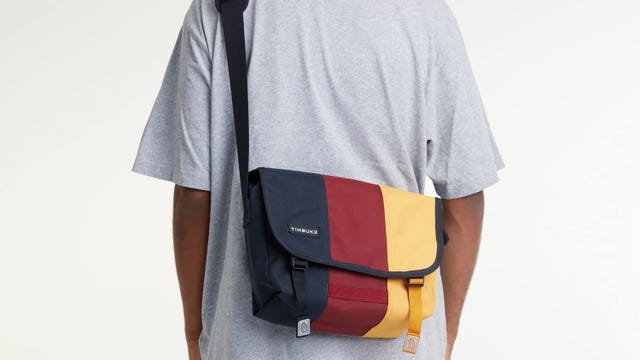 A blue, red and yellow messenger bag on a persons back