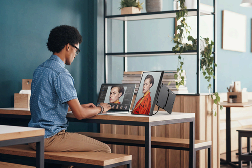 A person using a MacBook and the ViewSonic VP16-OLED for photo editing