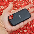 A hand holds the pocket-sized SanDisk Extreme portable 2TB SSD.