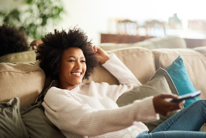 A person relaxing on a couch while watching TV. 