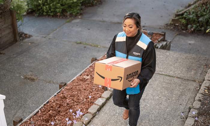 Amazon delivery person holding a box.