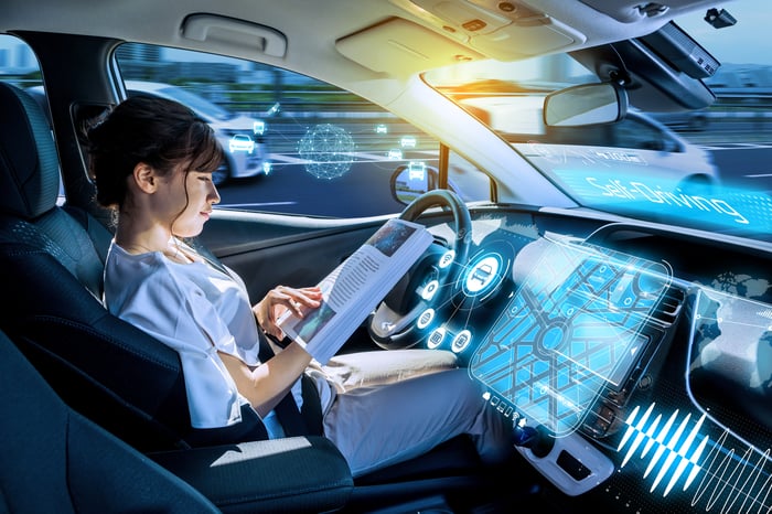 A person reads a book in a driverless vehicle.