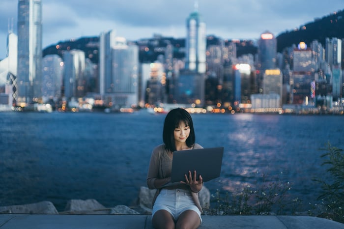 Person on laptop in front of a skyline.