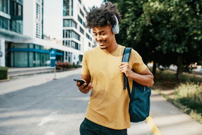 Young mobile phone user on urban street.